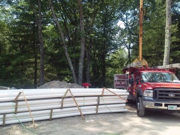 truck dropping off materials for a geothermal wall installation