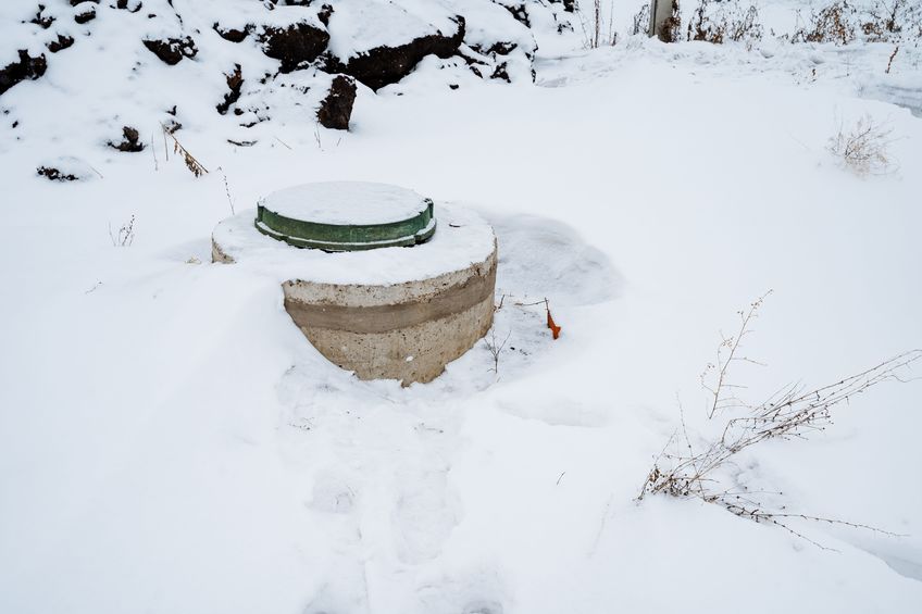 a water well in the backyard is covered by snow in the winter